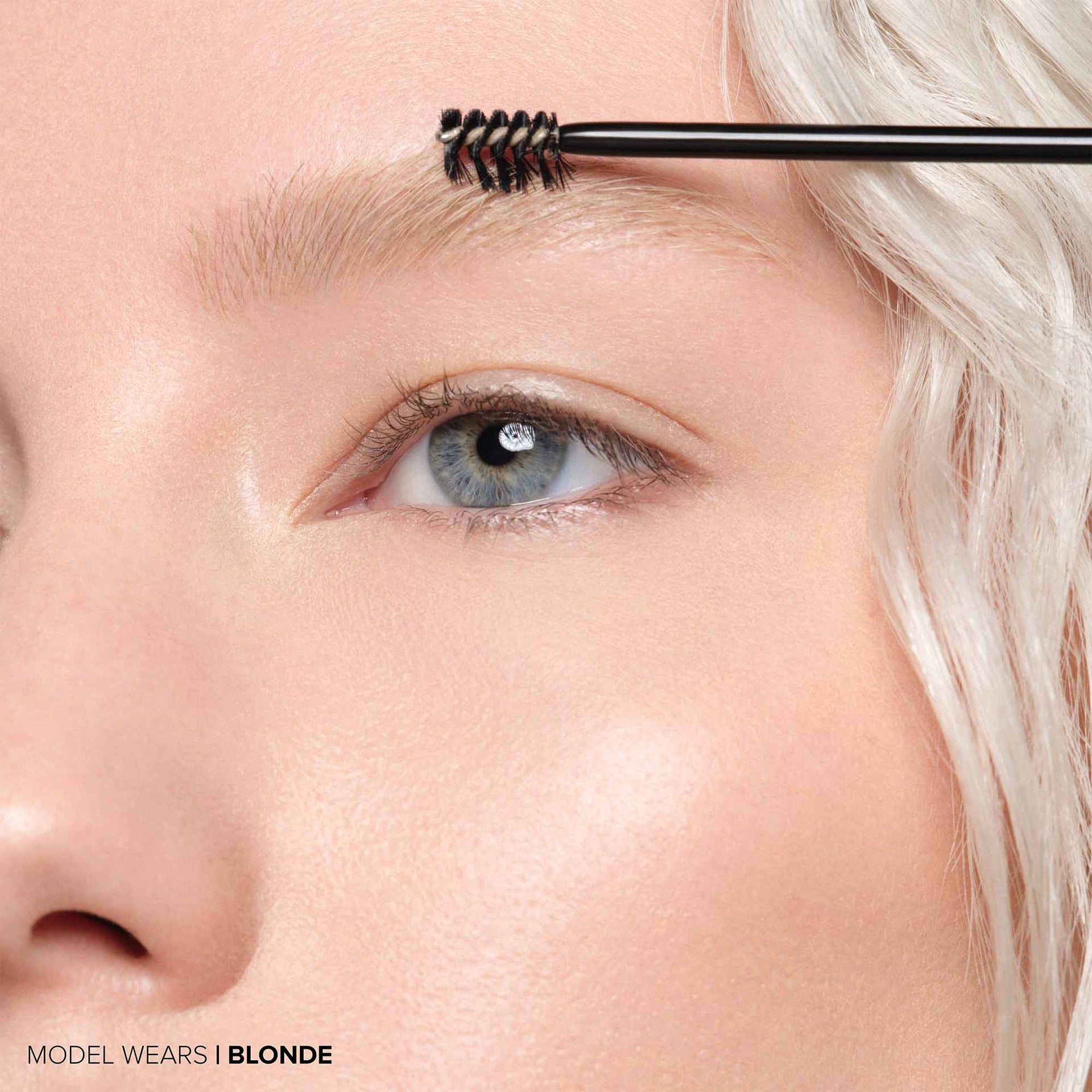 Blonde | Volumizing Tinted Brow Gel -Model Holding Product Wand